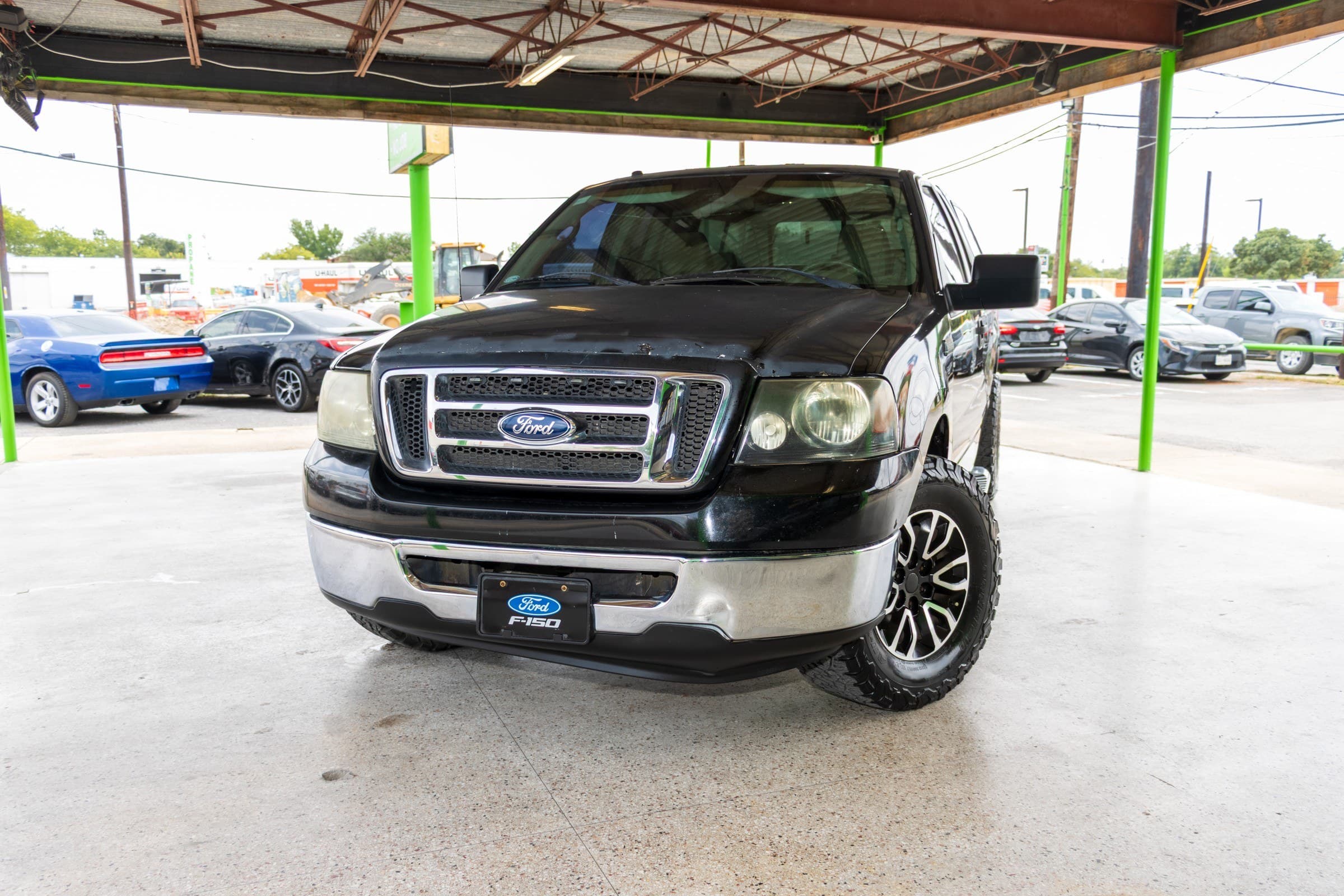 Head-on front view of the black F-150, showing the chrome grille surround, Ford oval and F-150 front plate.