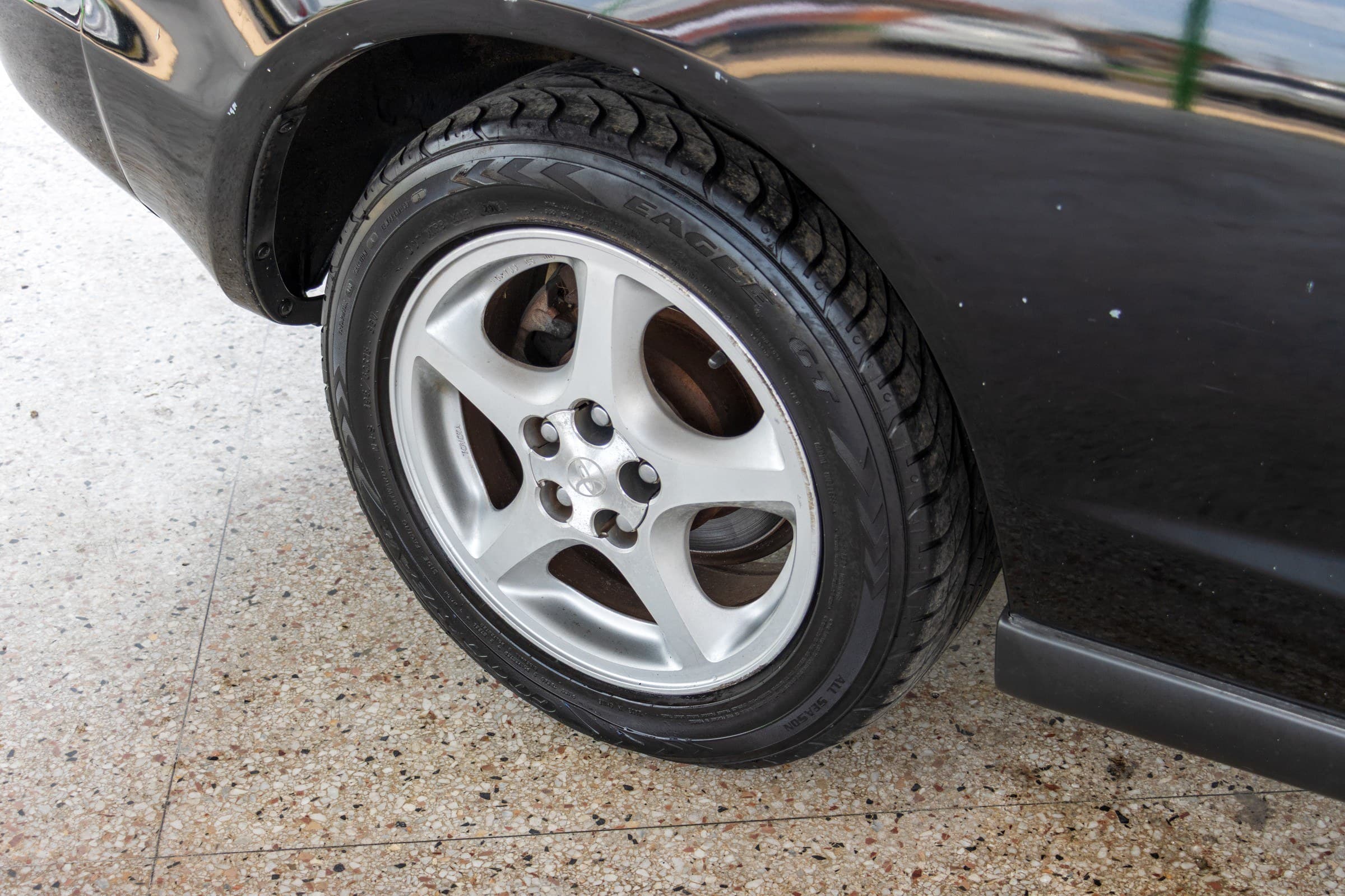 Close-up of a silver five-spoke Celica alloy wheel and tire.