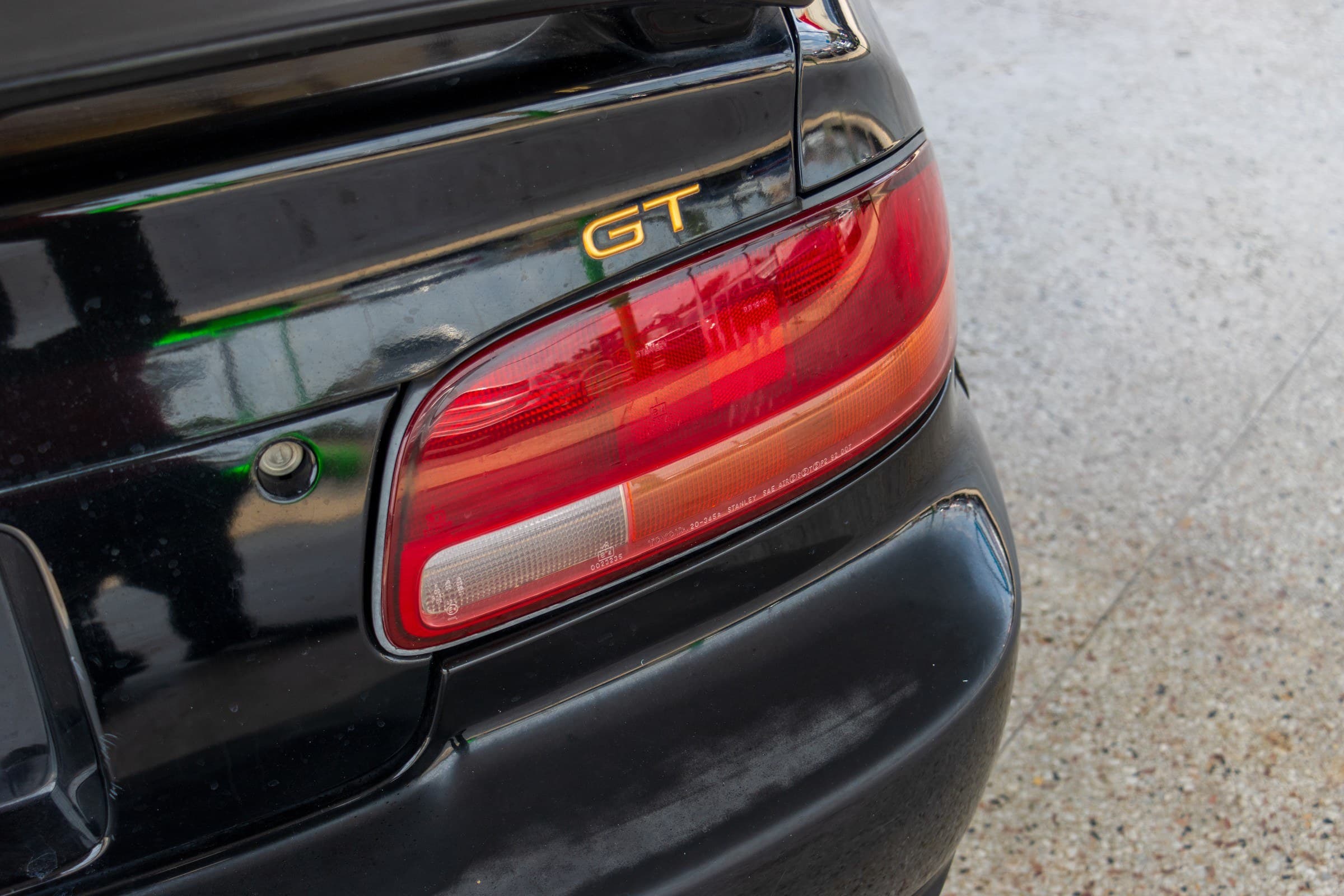 Close-up of the Celica's rear light cluster and the gold GT badge on the trunk lid.