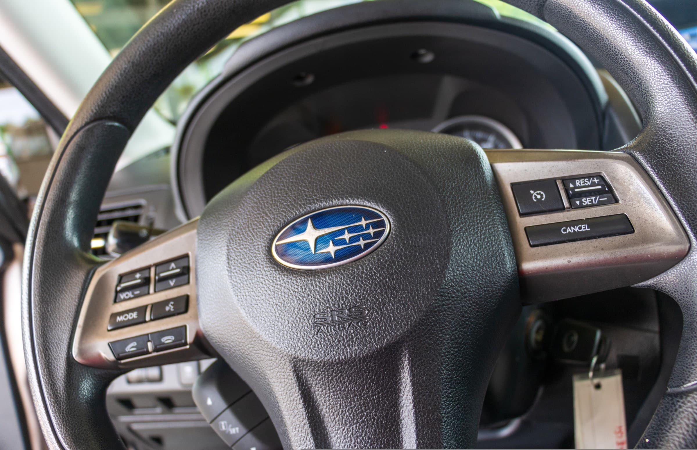 Close-up of the Forester's steering wheel, showing the Subaru badge and the cruise control, audio and phone buttons on the spokes.