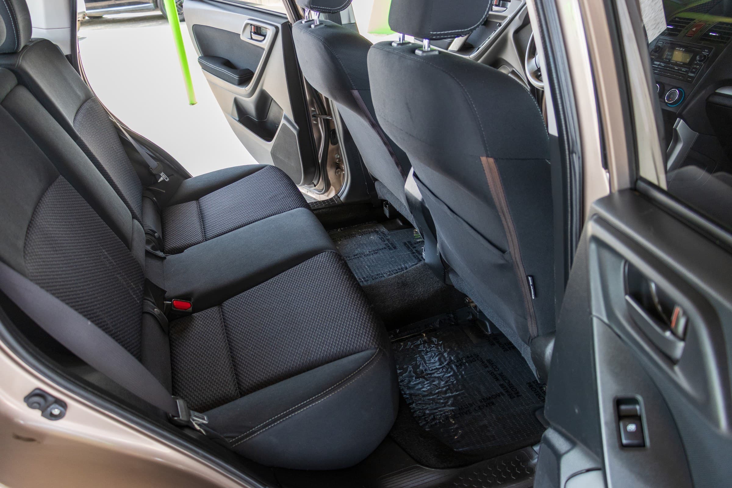 Black cloth rear bench of the Forester seen through the open rear door.