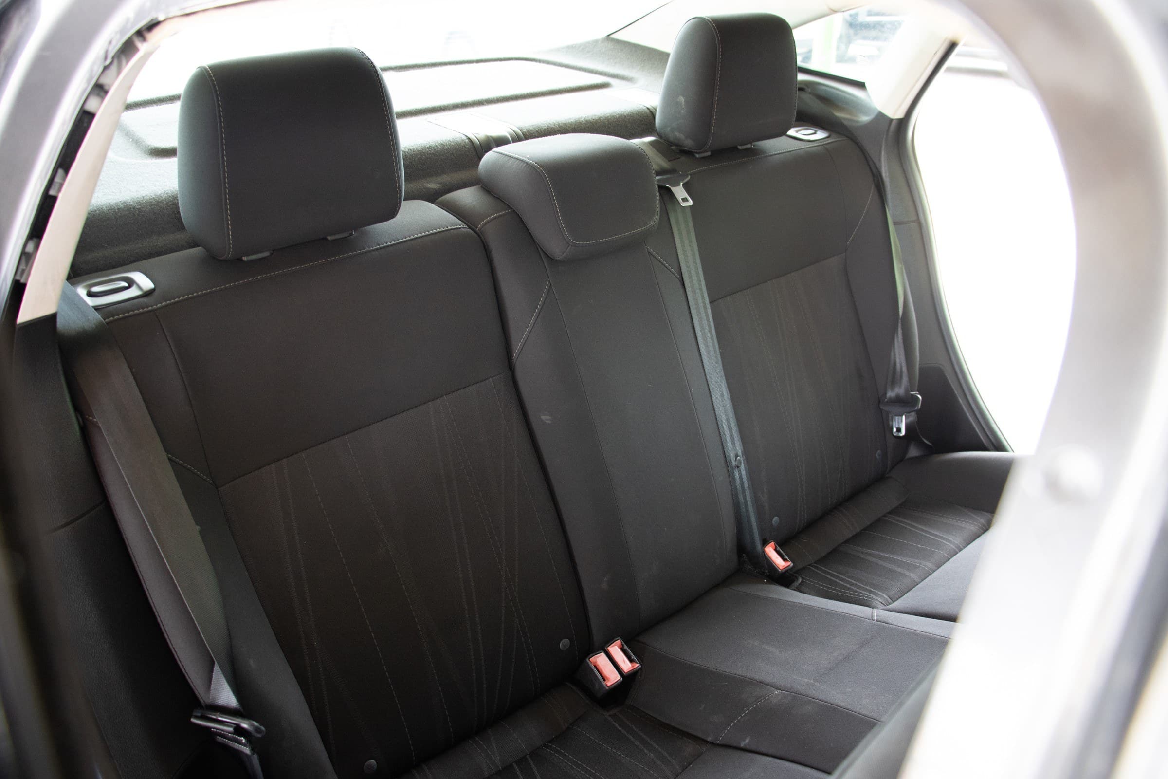 Black cloth rear bench of the Ford Focus seen through the open rear door.