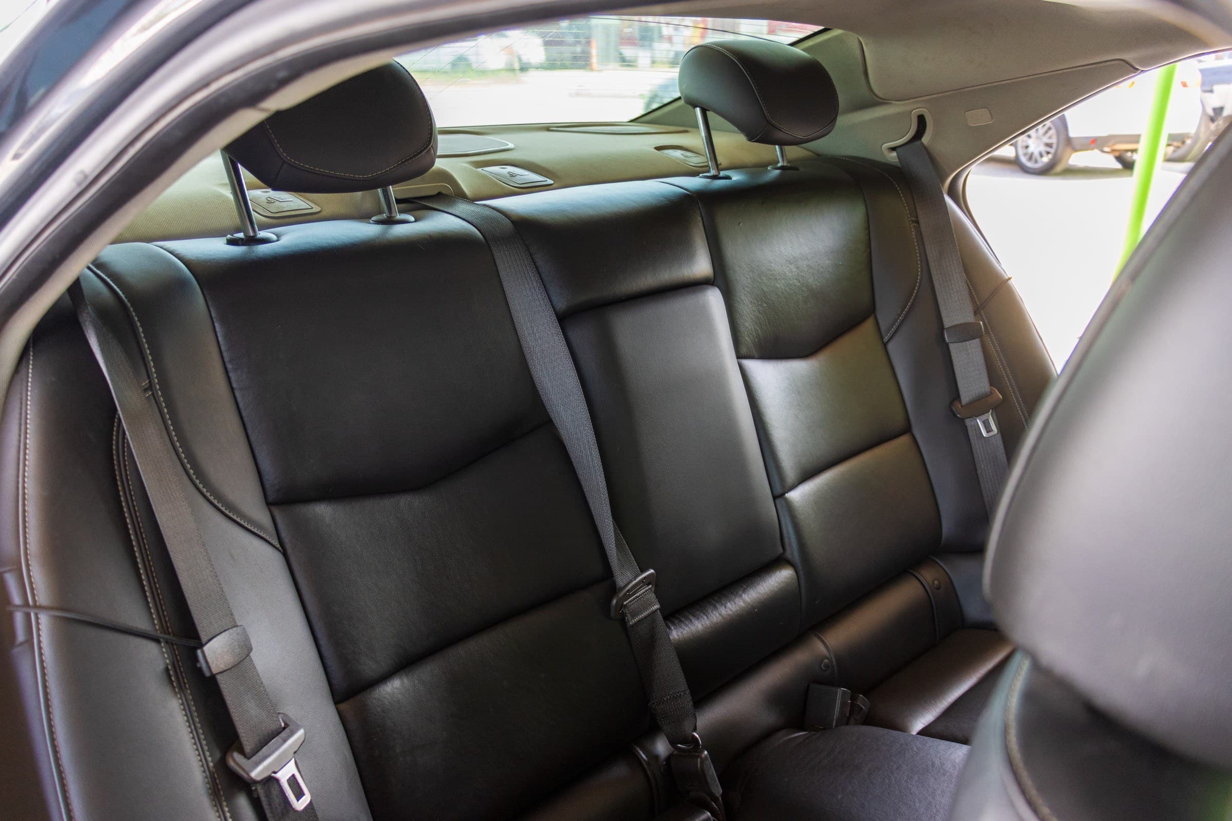 The ATS's black leather rear bench seen from the passenger side, with the rear parcel shelf above.
