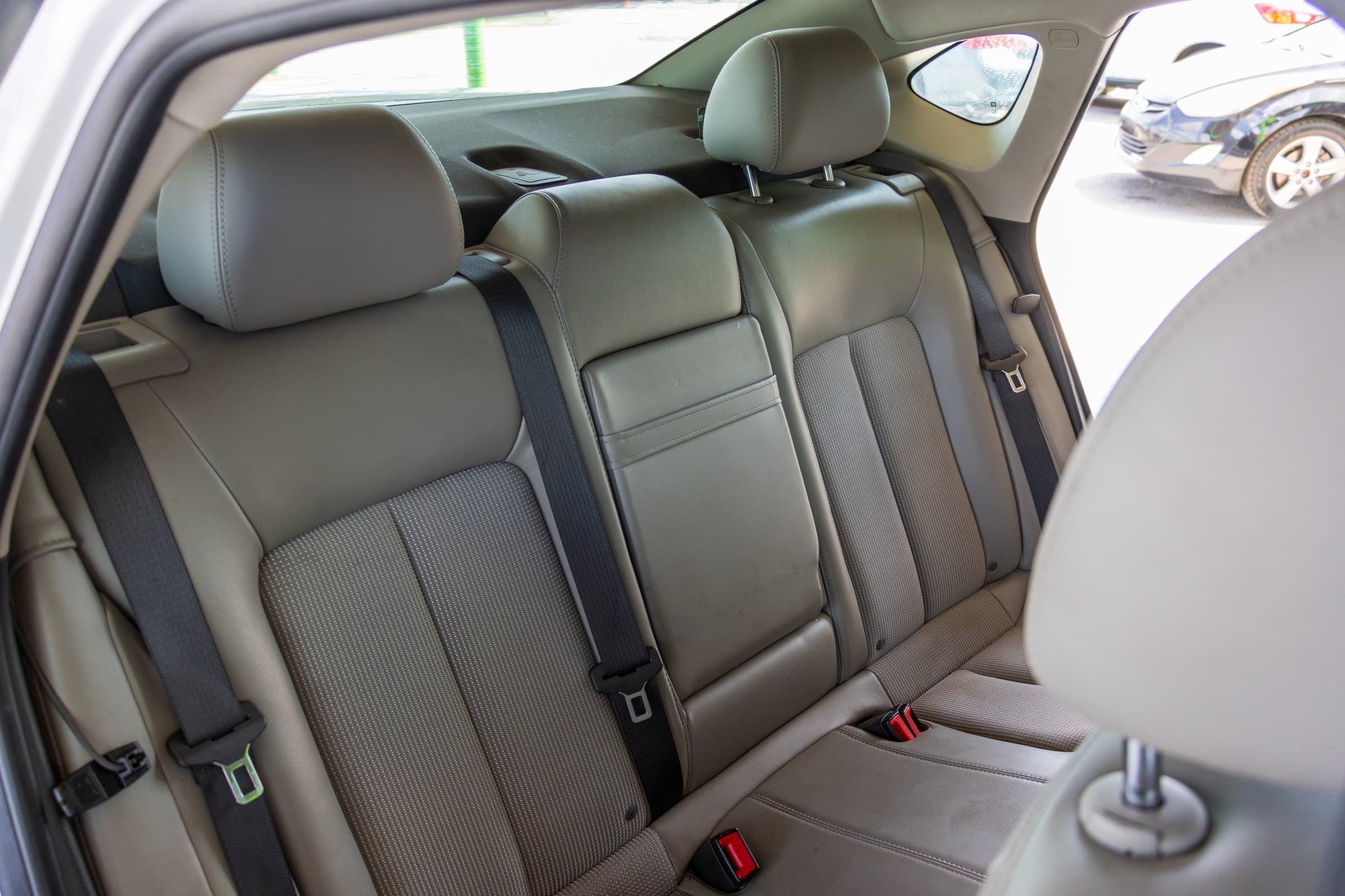 Light grey leather rear bench of the Buick Verano seen through the open rear door.